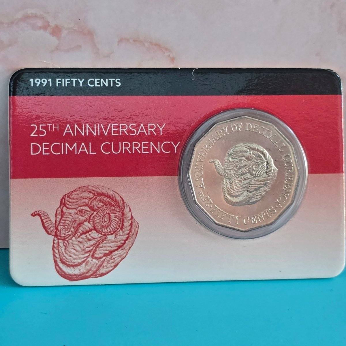 1991 Ram's Head fifty cents coin reverse in a Downies display card with '25th Anniversary Decimal Currency' text