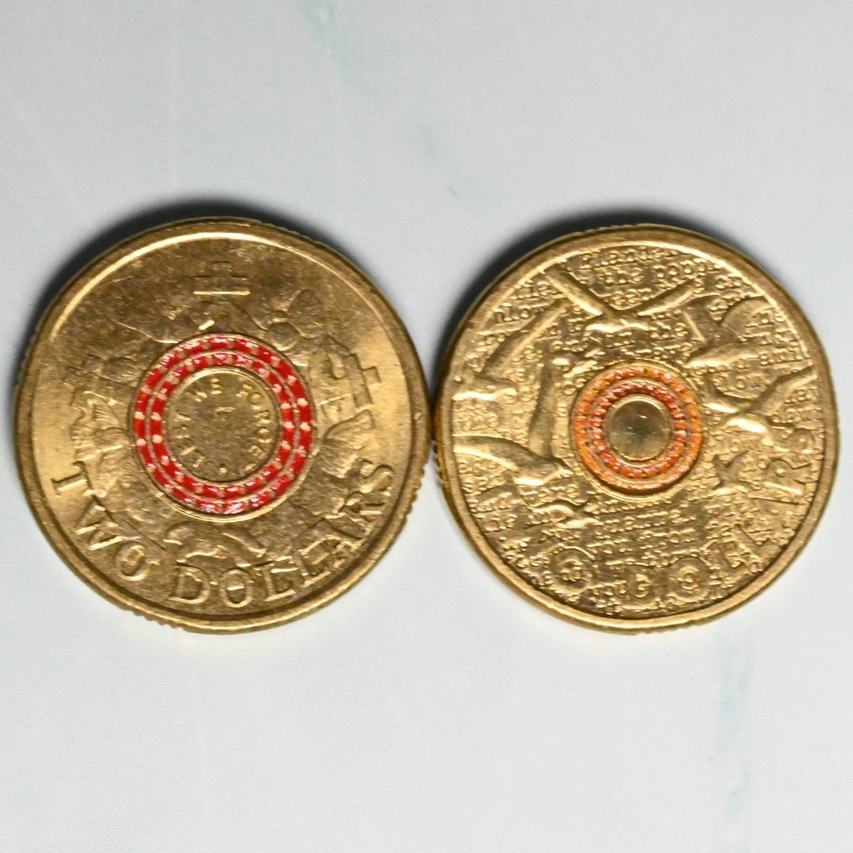 2015 $2 Red ANZAC Cove and Orange Flanders Fields Remembrance coins in circulated condition reverse side