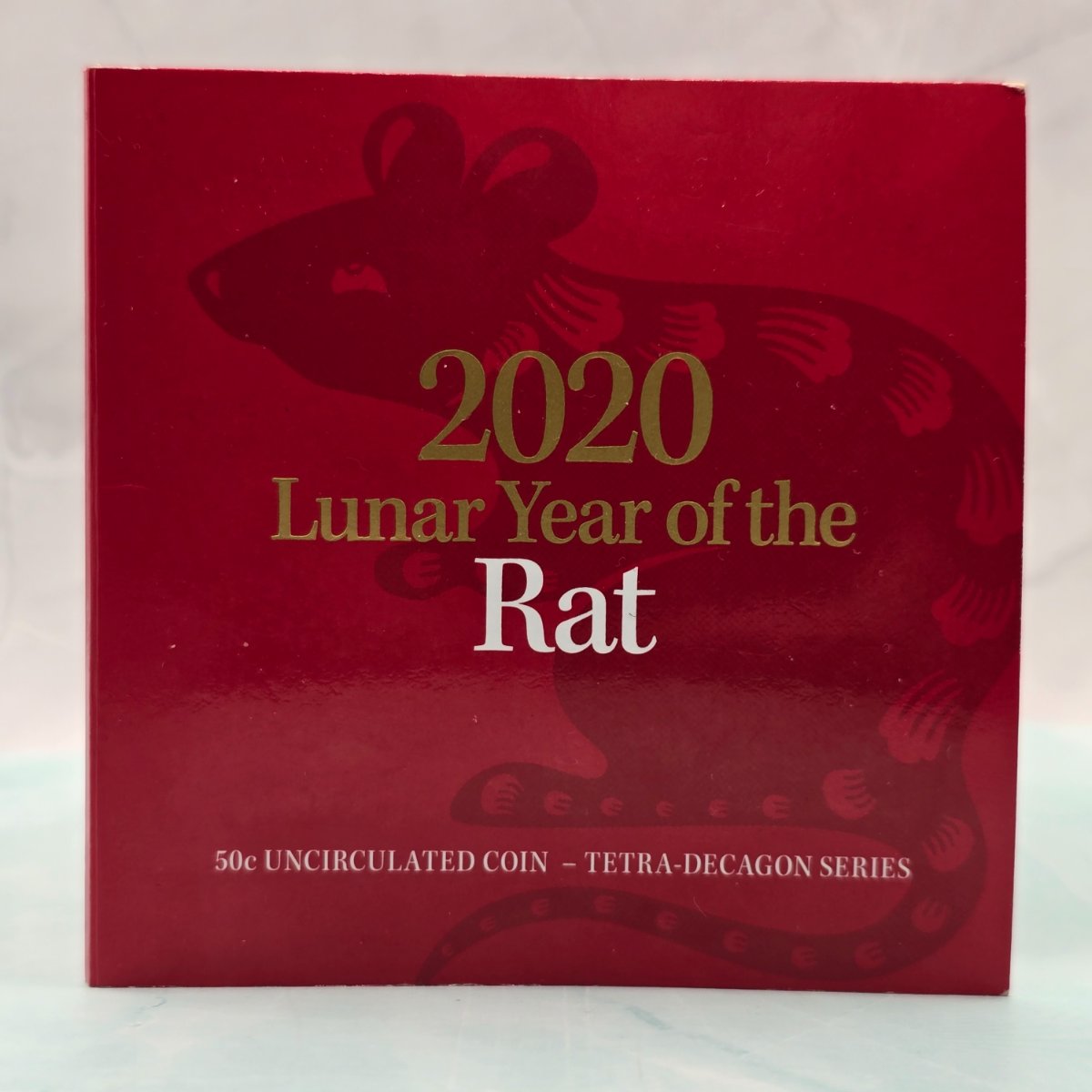 2020 50c Lunar Year of the Rat 50c Uncirculated Coin Tetra Decagon Series front of red trifold with gold foil accents