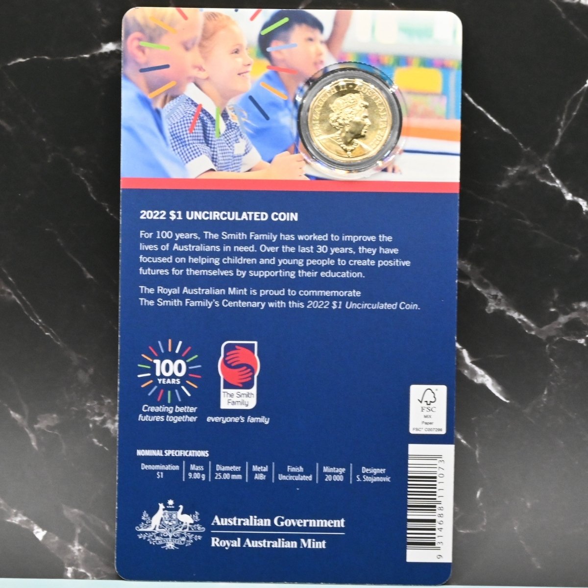 2022 $1 Centenary of the Smith Family carded coin with information text and nominal specifications - obverse