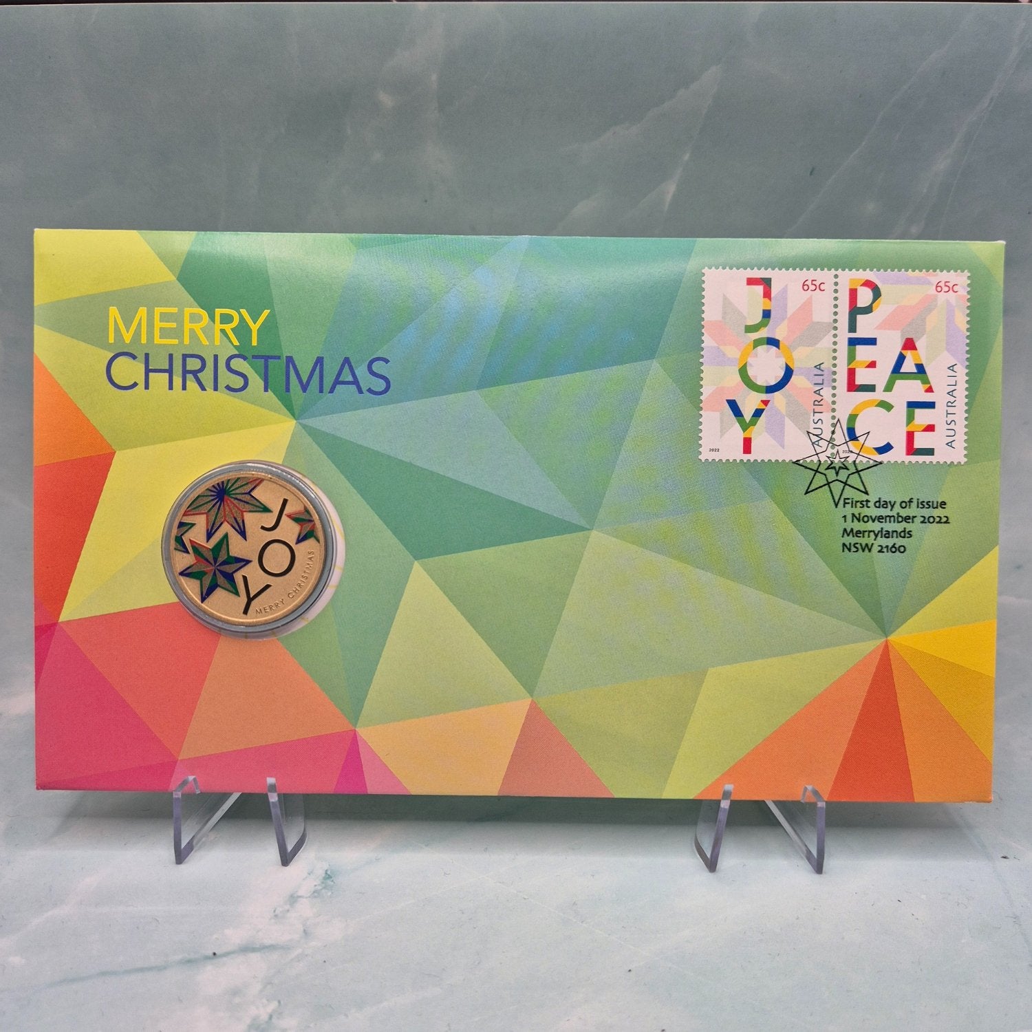Front of 2022 $1 Perth Mint Merry Christmas JOY PNC - Coloured coin - reverse shown - PNC text 'Merry Christmas' - Stamps text 'Joy' 'Peace'