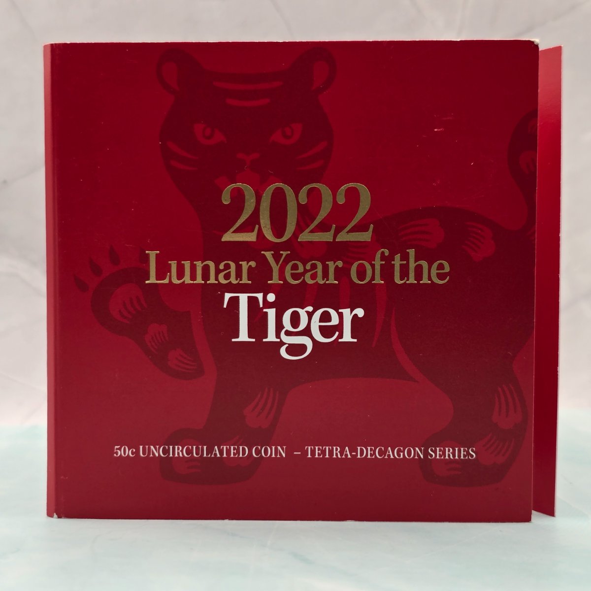 2022 50c Lunar Year of the Tiger 50c Uncirculated Coin Tetra Decagon Series front of red trifold with gold foil accents