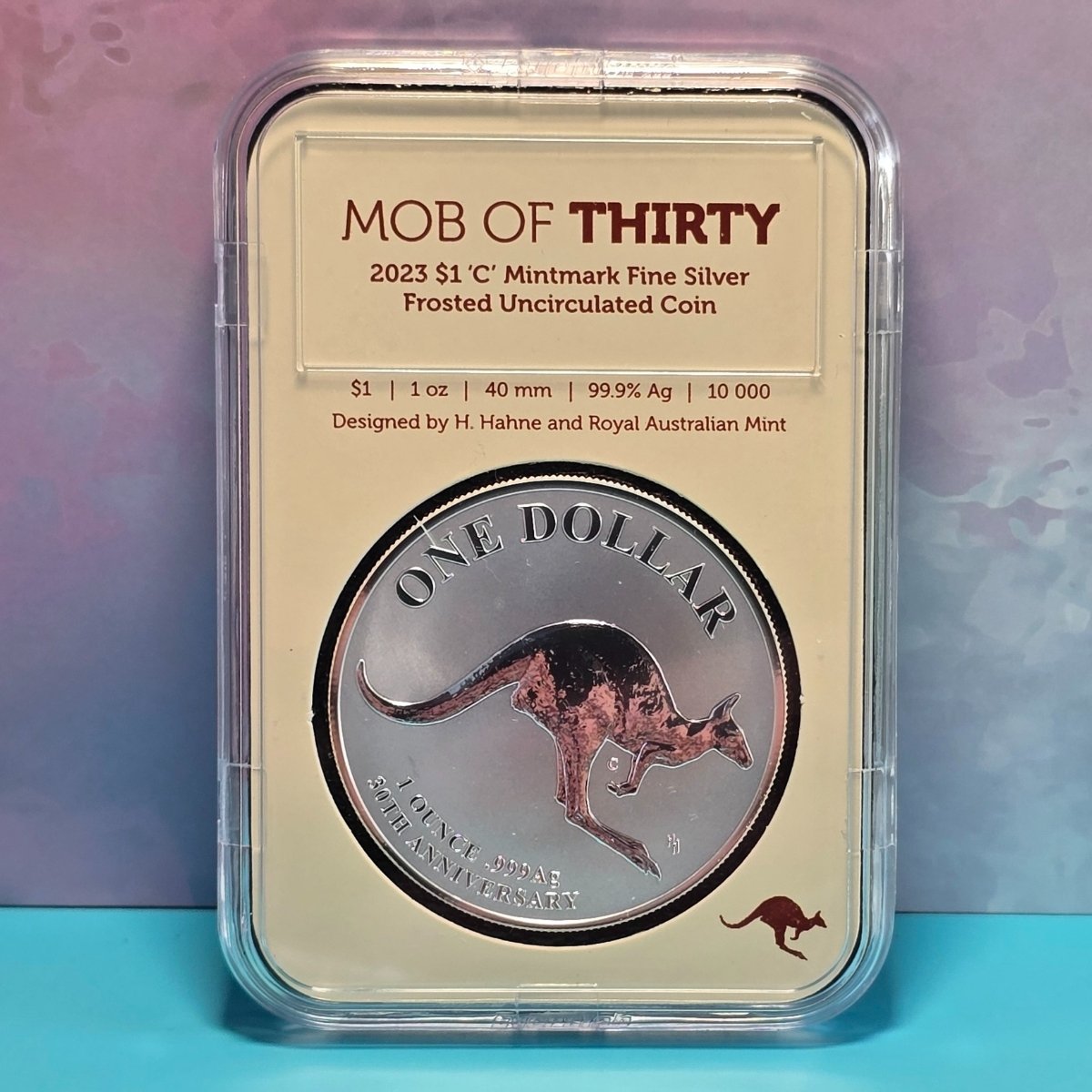 Silver coin in a protective case with 'MOB of Thirty - 2023 $1 'C' Mintmark Fine Silver - Frosted Uncirculated Coin' text - reverse side