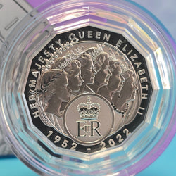 Silver coin commemorating Queen Elizabeth II with a clear protective case on a blue background