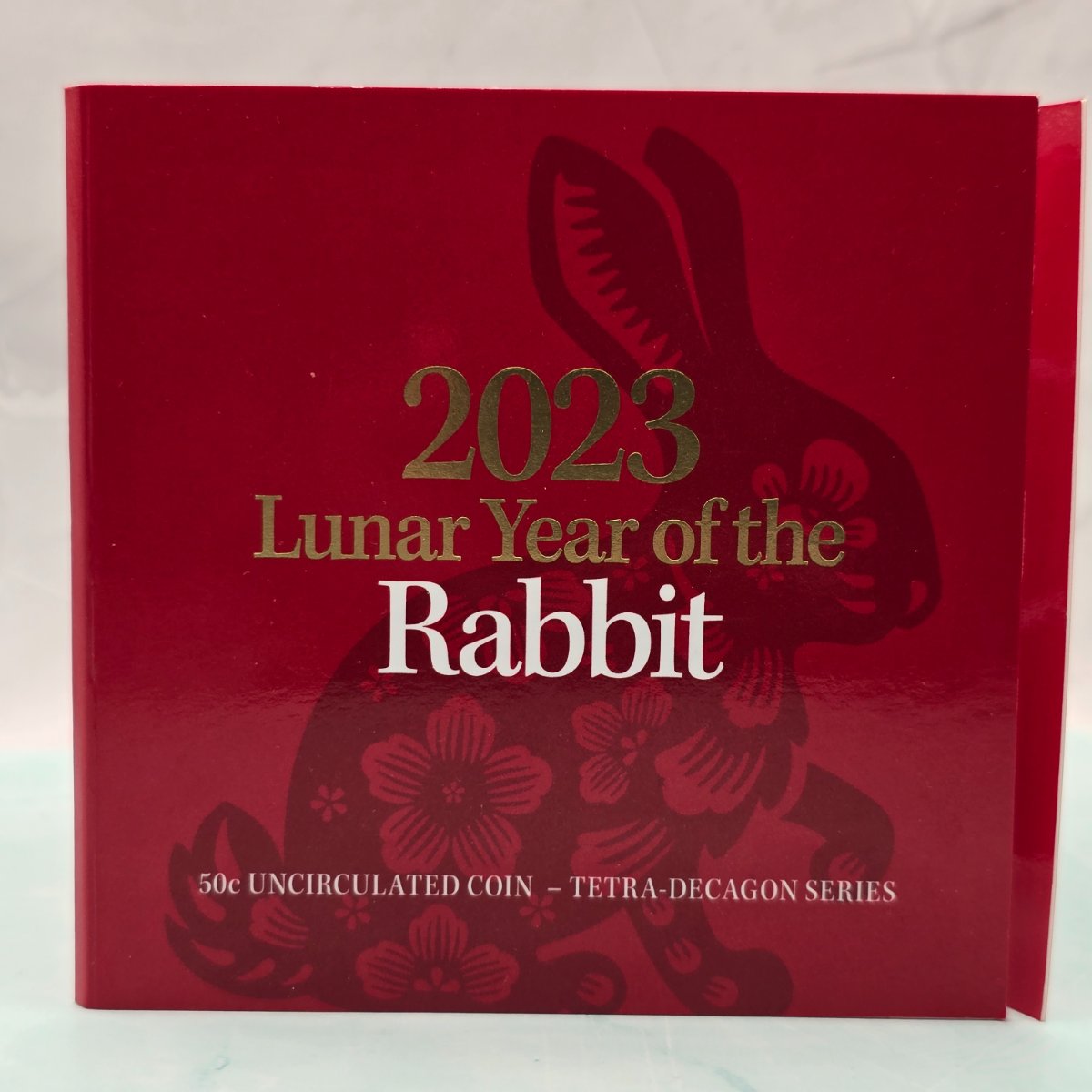 2023 50c Lunar Year of the Rabbit 50c Uncirculated Coin Tetra Decagon Series front of red trifold with gold foil accents