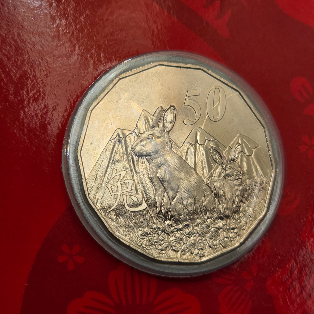 2023 50c Lunar Year of the Rabbit 50c Uncirculated Coin Tetra Decagon Series reverse with Rabbit in the grass, mountains behind, Chinese character for rabbit and denomination top right