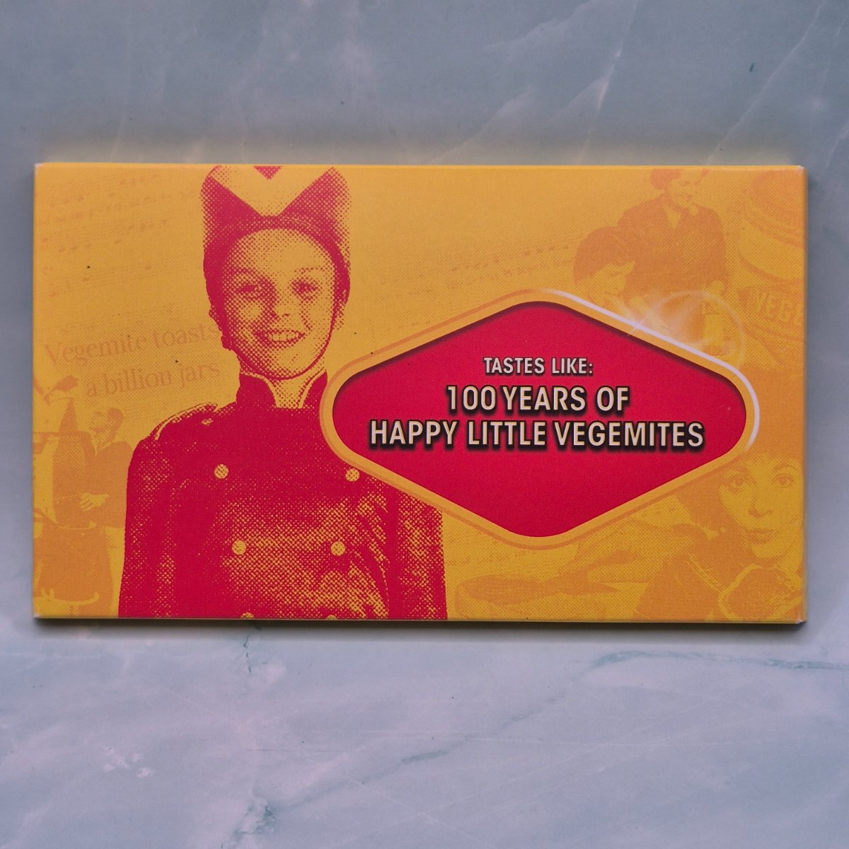 Vegemite Royal Australian Mint 6 coin year set packaging with a vintage-style illustration of a child and text on a yellow background.