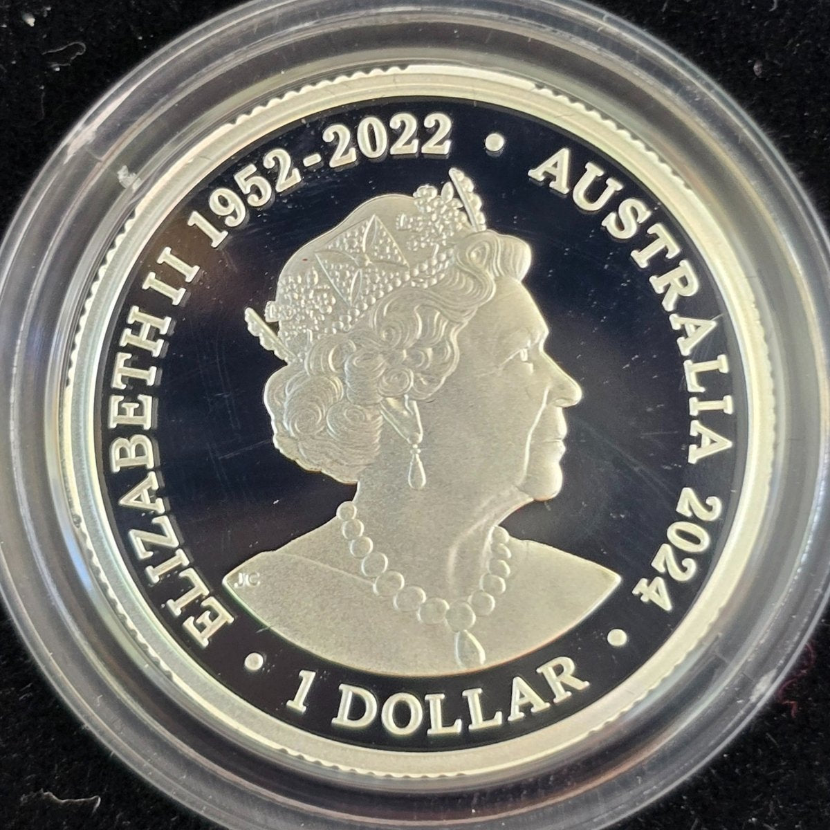 Silver $1 coin with Queen Elizabeth II 1952-2022 portrait and text 'Australia 2024' on a black background