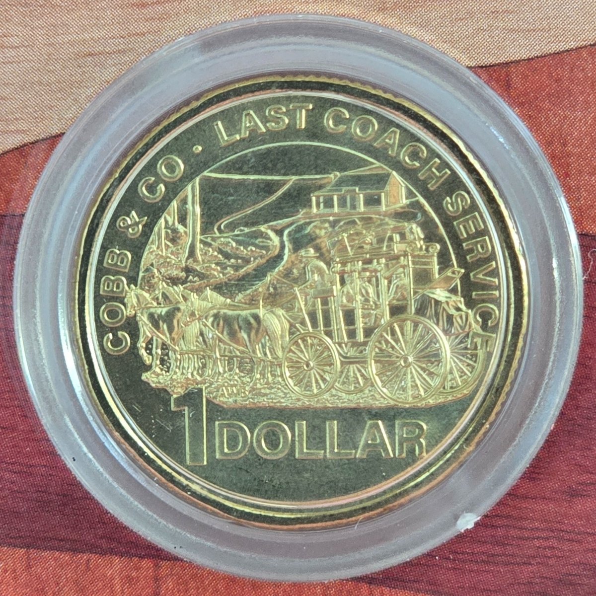 2024 one dollar $1 gold-colored coin with a horse-drawn carriage design - text ' Cobb & Co. Last Coach Service 1 Dollar' - reverse side