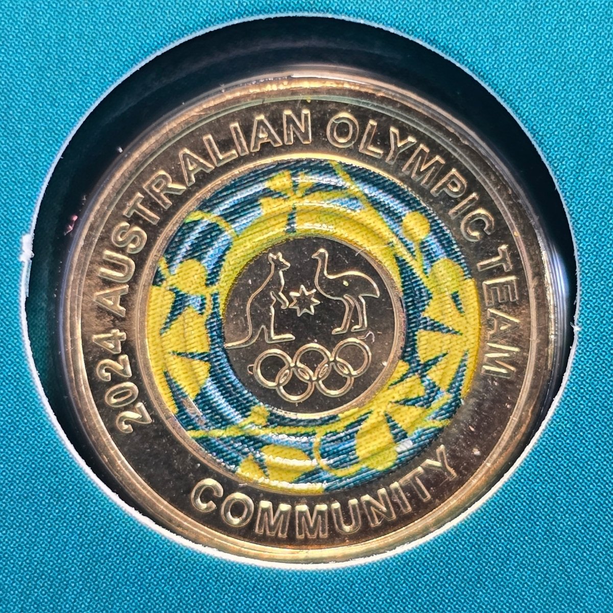 2024 $2 coin with 'Australian Olympic Team' and 'Community' text - colour surrounds an image of a kangaroo and emu with star between above olympic rings - reverse of coin