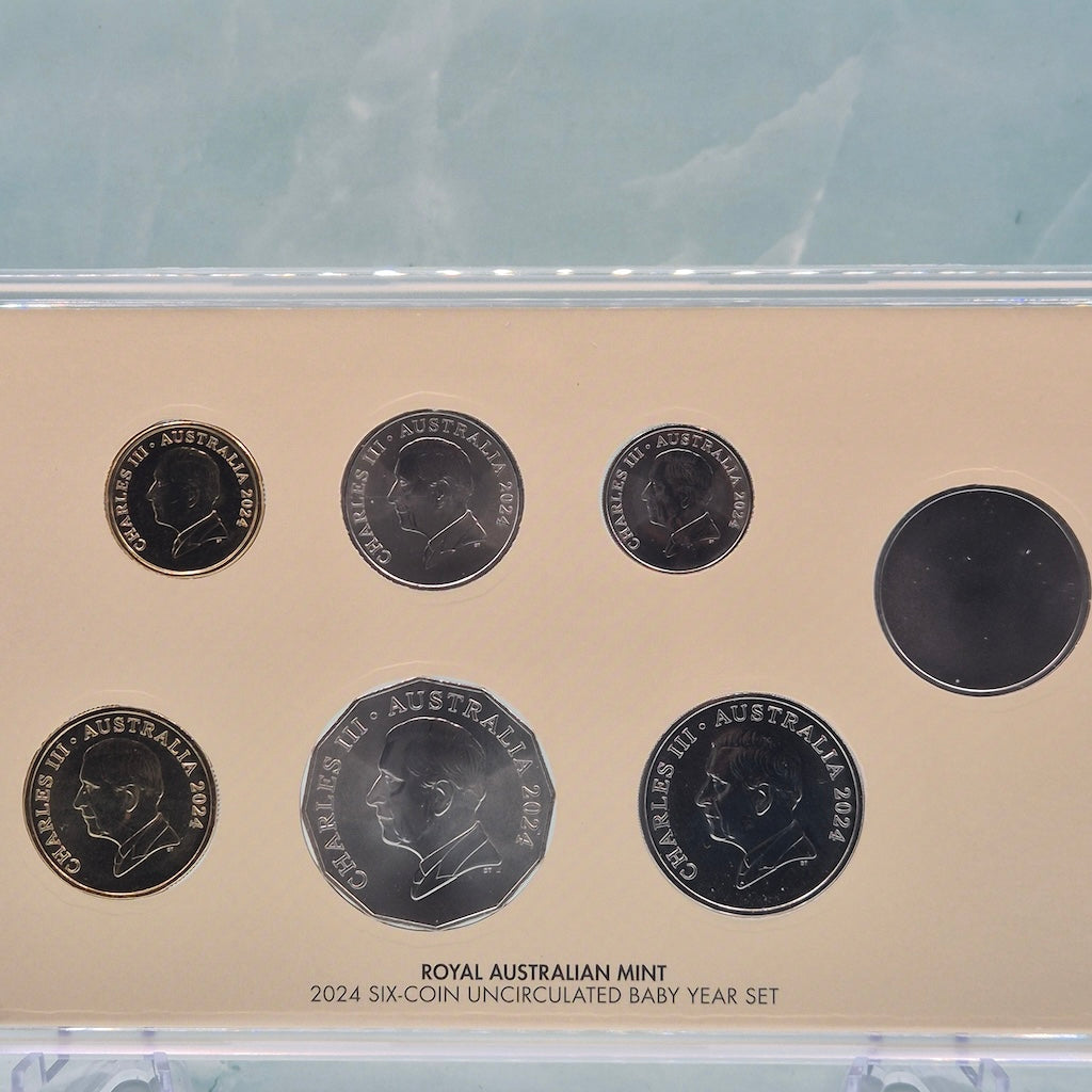 Obverse of six coins from the 2024 RAM Baby Mint Set with King Charles III Effigy on all denominations and plain side of a token